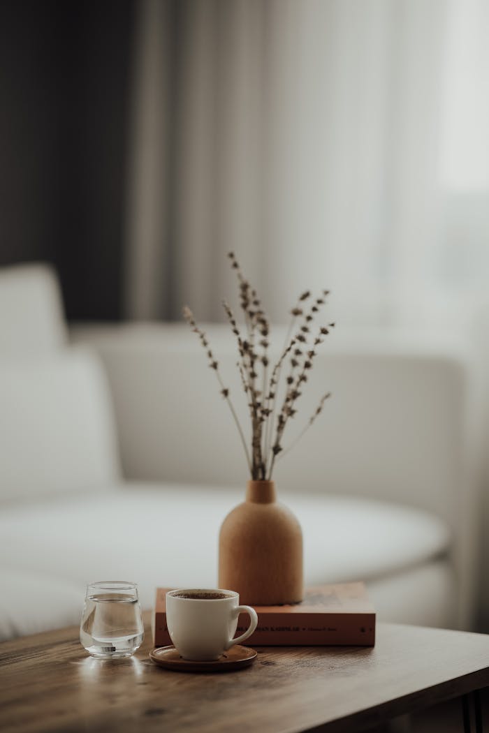 Mastering the First Impression: Your intriguing post title goes here Warm minimalist home interior with a coffee cup, book, and vase on a wooden table.